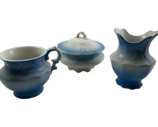 717 - 3pc Champion Wash Set (Description): A three-piece Champion set featuring a coordinated blue and white ceramic grouping. The set includes a cup with handle, a lidded covered dish, and a Vase.