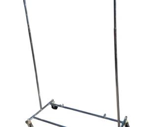 1019 - Rolling Metal Clothes Rack 67"x56" (Description): Rolling metal clothes rack featuring a chrome finish and mounted on four casters for easy mobility. The rack includes a single horizontal hanging bar supported by two vertical uprights on a rectangular wheeled base. Measures 67 inches by 56 inches.