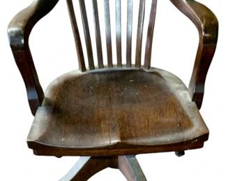 1117 - Wood Desk Chair 33"x24"x24" (Description): A classic wood desk chair featuring a slatted back design with curved armrests. The chair sits on a four-legged swivel base with casters for mobility. Measures 33 inches high by 24 inches wide by 24 inches deep.