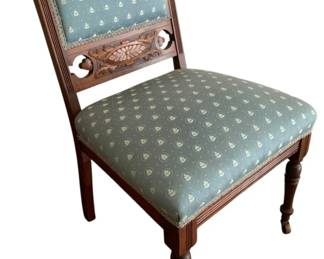 338 - Upholstered Victorian Chair 32"x20"x20" (Description): Upholstered antique wood chair featuring carved wooden details and turned front legs. The chair is upholstered in a light blue fabric with a decorative pattern. Measures 32 inches tall by 20 inches wide by 20 inches deep.