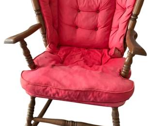 749 - Wooden Rocker w/ Cushion 35"x29"x29" (Description): Features turned spindle construction with armrests and comes with a tufted red cushion set. Measures 35 inches by 29 inches by 29 inches.