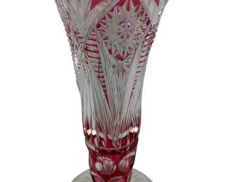 305 - Bohemian Red Cut to Clear Vase 8" (Description): A ruby and crystal vase featuring intricate cut glass patterns. The piece displays rich ruby coloring contrasted with clear crystal sections, showcasing detailed craftsmanship in the cut design. Measures 8 inches in height.