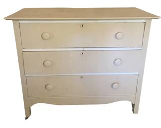 779 - 3 Drawer White Chest 34"x40"x18" (Description): Three drawer white chest featuring round wooden knobs on each drawer and keyhole escutcheons. The piece rests on casters for easy mobility. Measures 34 inches tall by 40 inches wide by 18 inches deep.