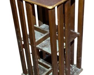 1119 - Revolving Wood Bookshelf 28"x14"x14" (Description): Revolving wood bookshelf featuring multiple tiers for book storage. The unit rotates for easy access to all sides. Measures 28 inches tall by 14 inches wide by 14 inches deep.