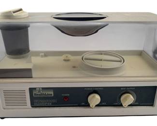 800 - Healthline Ultrasonic Humidifier 9"x15"x6" (Description): Healthline Ultrasonic Humidifier featuring power control and mist output adjustment knobs. The unit has a clear plastic cover with a removable top opening and internal components for ultrasonic mist generation. Measures 9 inches by 15 inches by 6 inches. Used as-is electric/electronic/mechanical item. No guarantee all components present, untested if not otherwise stated.