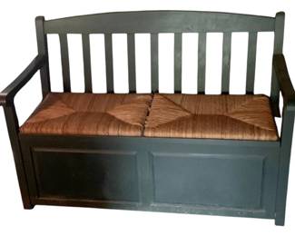 1095 - Storage Bench w/ Contents 34.5"x51"x26.5" (Description): Storage bench with contents included. Features a slatted back design with curved arms and a woven rush seat that lifts to reveal interior storage compartment. Measures 34.5 inches high by 51 inches wide by 26.5 inches deep.