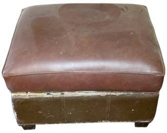 1104 - Vintage Ottoman 17"x26"x22" (Description): Vintage ottoman with a brown leather-style cushioned top and a contrasting darker base. Measures 17 inches by 26 inches by 22 inches.