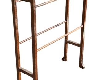 1143 - Johnson Quilt Rack 31.5"x25"x8" (Description): Johnson quilt rack constructed of wood with multiple horizontal bars for displaying quilts or textiles. The rack features a freestanding A-frame design with sturdy legs. Measures 31.5 inches high by 25 inches wide by 8 inches deep.