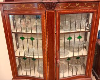 Antique-Style Glass Display Cabinet – Elegant wooden display cabinet featuring glass and decorative green stained-glass accents.