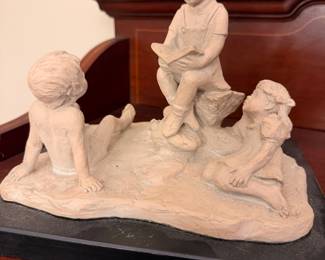 Children Reading Figurine – Charming sculpture depicting three children reading together.