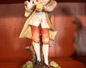 Vintage Porcelain Figurines – Decorative figures depicting a young man and woman in period clothing.