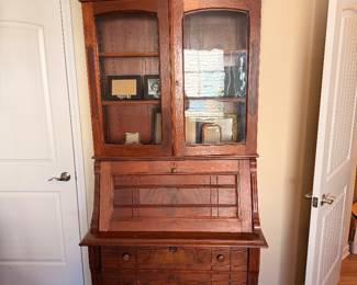 Antique Secretary Bookcase – Impressive wooden bookcase featuring glass doors, drop-front writing surface, interior compartments, and storage drawers.