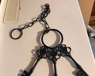 Decorative wrought iron key ring featuring three oversized skeleton-style keys attached to a chain.