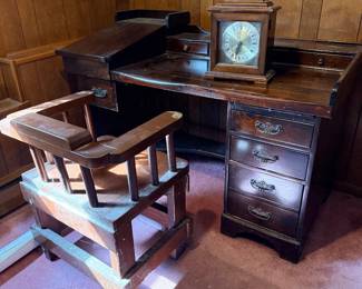 Vintage dark stain wooden desk set featuring a slanted-top side cabinet, a wooden barrel-back swivel desk chair, and a bracket-top bracket clock.
