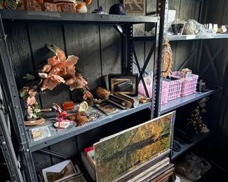 Metal shelving units filled with assorted collectibles, including Boston Red Sox memorabilia, framed artwork, artificial flowers, and various home decor items.