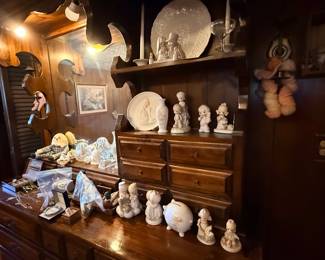 Vintage dark wood hutch and dresser filled with a collection of ceramic figurines, porcelain collectibles, glassware, and jewelry boxes.
