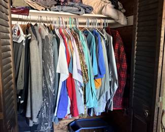 Cedar-lined closet filled with assortment of men's clothing, including shirts, jackets, and trousers, along with shoes and folded garments.
