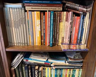 Wooden bookcase filled with a large collection of vintage non-fiction books, including various woodworking, reference, and natural history volumes.