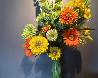 Lot 6: Colorful artificial flower bouquet in a green glass vase