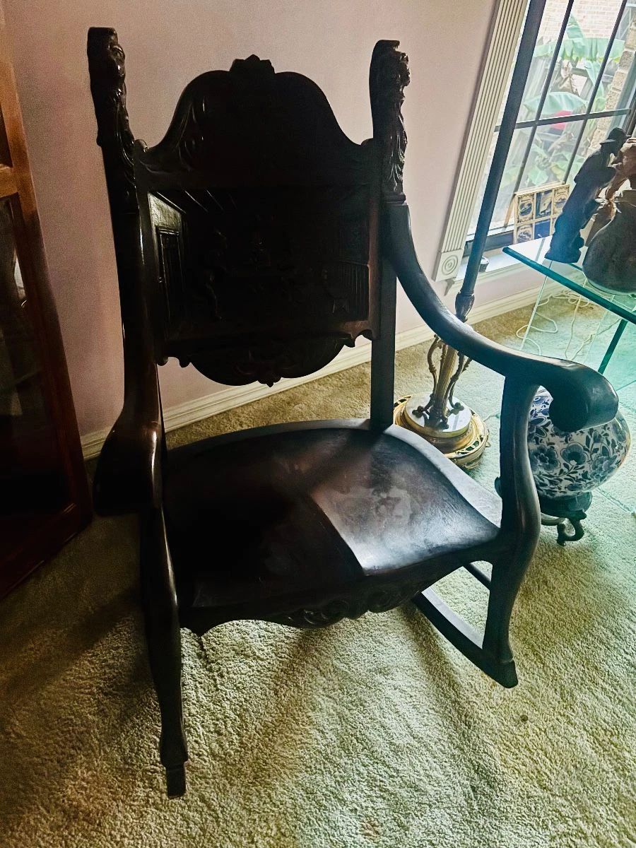 Antique-style carved dark wood armchair with scrolled arms