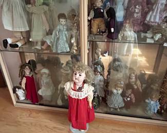 Display cabinet of dolls with doll in red dress