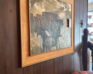 Framed abstract painting in wide wood frame on paneled wall