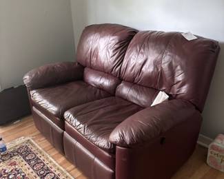 Burgundy leather reclining loveseat with Persian-style rug