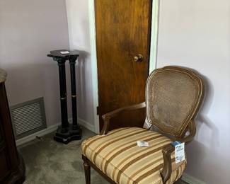 Upholstered striped armchair with cane back and pedestal stand