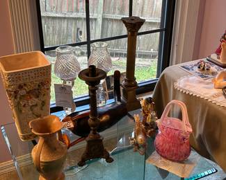 Glass table with brass candlesticks, vases and art glass