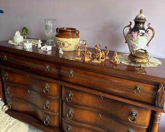 Mahogany-finish serpentine dresser with porcelain and brass decor