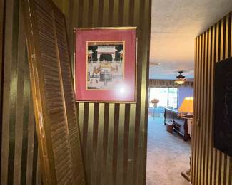 Gold-striped wall with framed print and louvered door