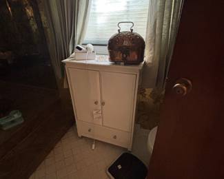 White two-door cabinet with copper kettle and bath scale