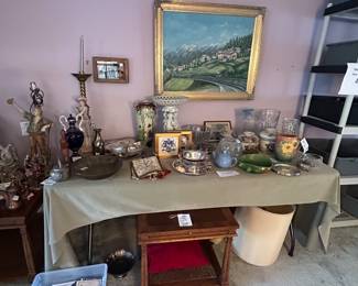 Table of figurines, lamps and framed landscape painting