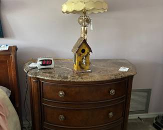 Marble-top bowfront nightstand with crystal lamp and birdhouse