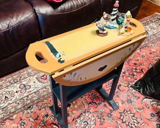 Painted drop-leaf table with figurines and leather sofa