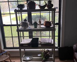 Metal shelf with pottery pitchers and brass decor