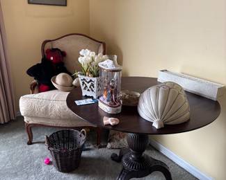 Bedroom corner with tilt-top table, settee and hats
