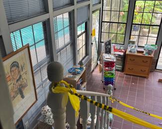 Stair view of sunroom with framed portrait and tables