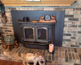 Brick hearth with wood stove insert and carved elephant