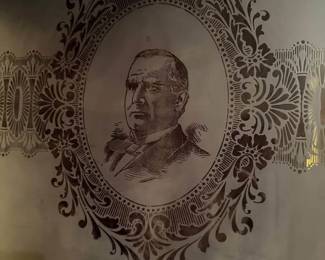 large frosted glass panel displays a detailed portrait of President McKinley surrounded by an elaborate Victorian-style floral and scrollwork design.