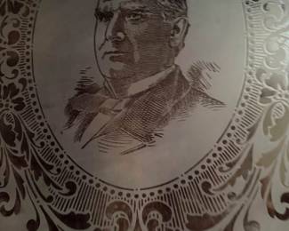 large frosted glass panel displays a detailed portrait of President McKinley surrounded by an elaborate Victorian-style floral and scrollwork design.