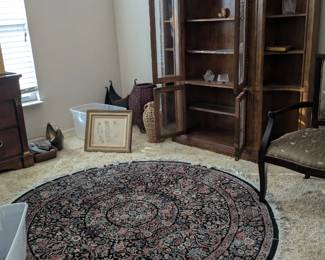 Display cabinet with two separate open sides, wool round Persian style rug, artwork