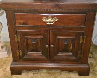 2 **Vintage Wooden Nightstand β Traditional Cabinet with Drawer** Classic wooden nightstand featuring a warm dark wood finish, single upper drawer, and double\-door lower cabinet\. Decorative raised\-panel doors, brass\-tone hardware, and traditional molding give this piece a charming vintage appearance\. Perfect as a bedside table, small storage cabinet, or accent piece in a living room\. **Condition:** Pre\-owned with minor signs of wear consistent with age and use\.