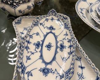 This is Royal Copenhagen Blue Fluted Full Lace porcelain dinnerware, featuring hand-painted blue floral and vine motifs with openwork lace borders.
