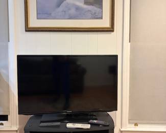 Rolling tv stand and tv. Art on the wall also up for grabs