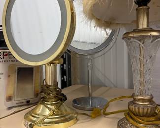 Lighted vanity mirror and feather shade lamp.