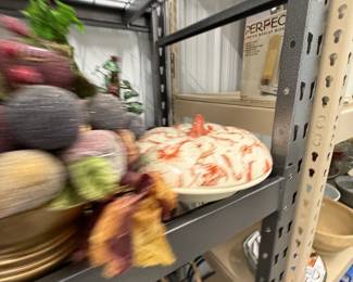 Faux fruit, florals, and decorative serving pieces.
