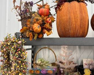 Fall decor: large faux pumpkins, harvest arrangements, and wreaths.