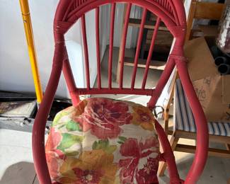 Red wicker chair with floral cushion.