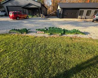 Giant handmade wooden yard crocs with painted teeth and eyes. One of a kind yard art.